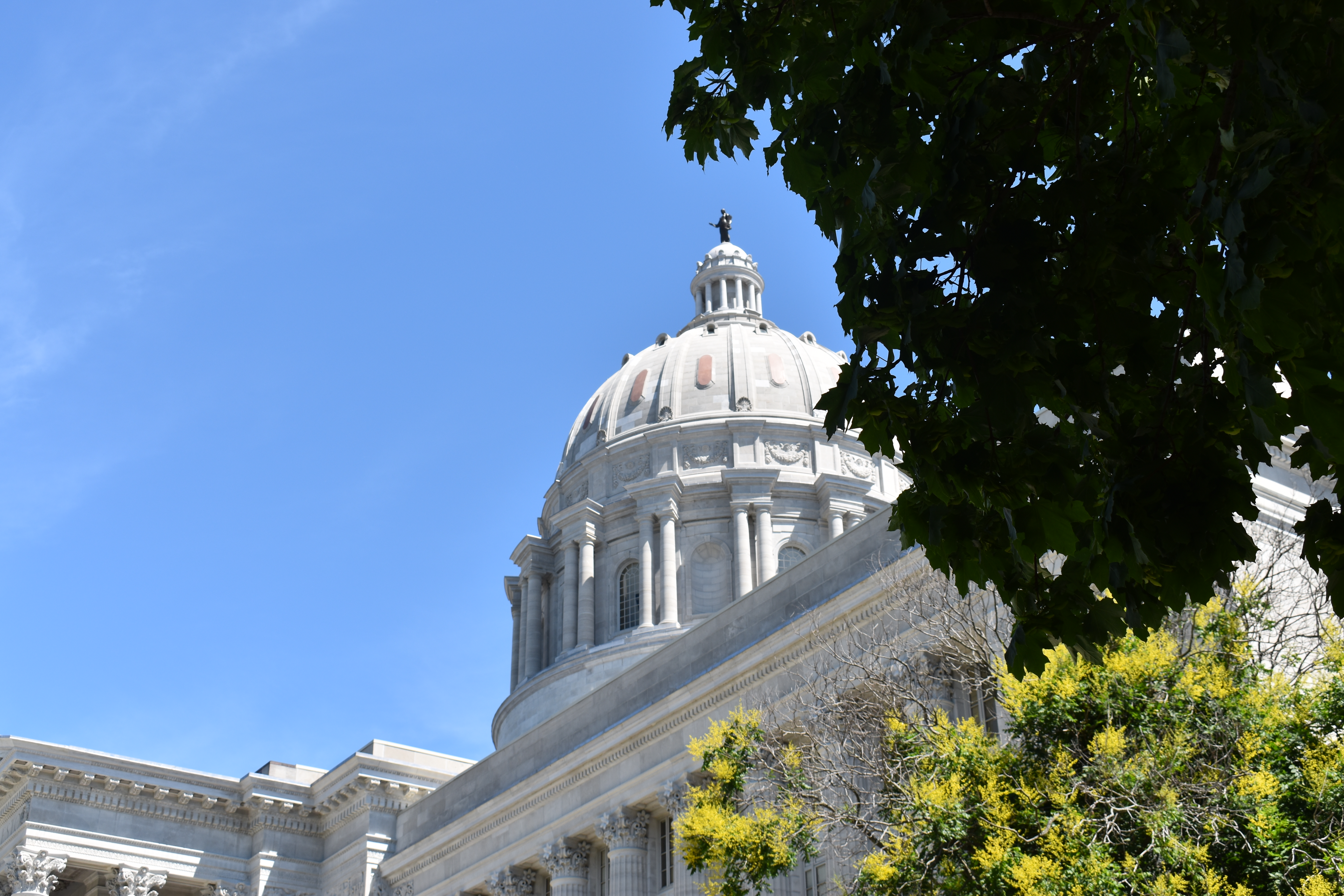zoomed in picture of dome and statue on top of missouri state capitol.